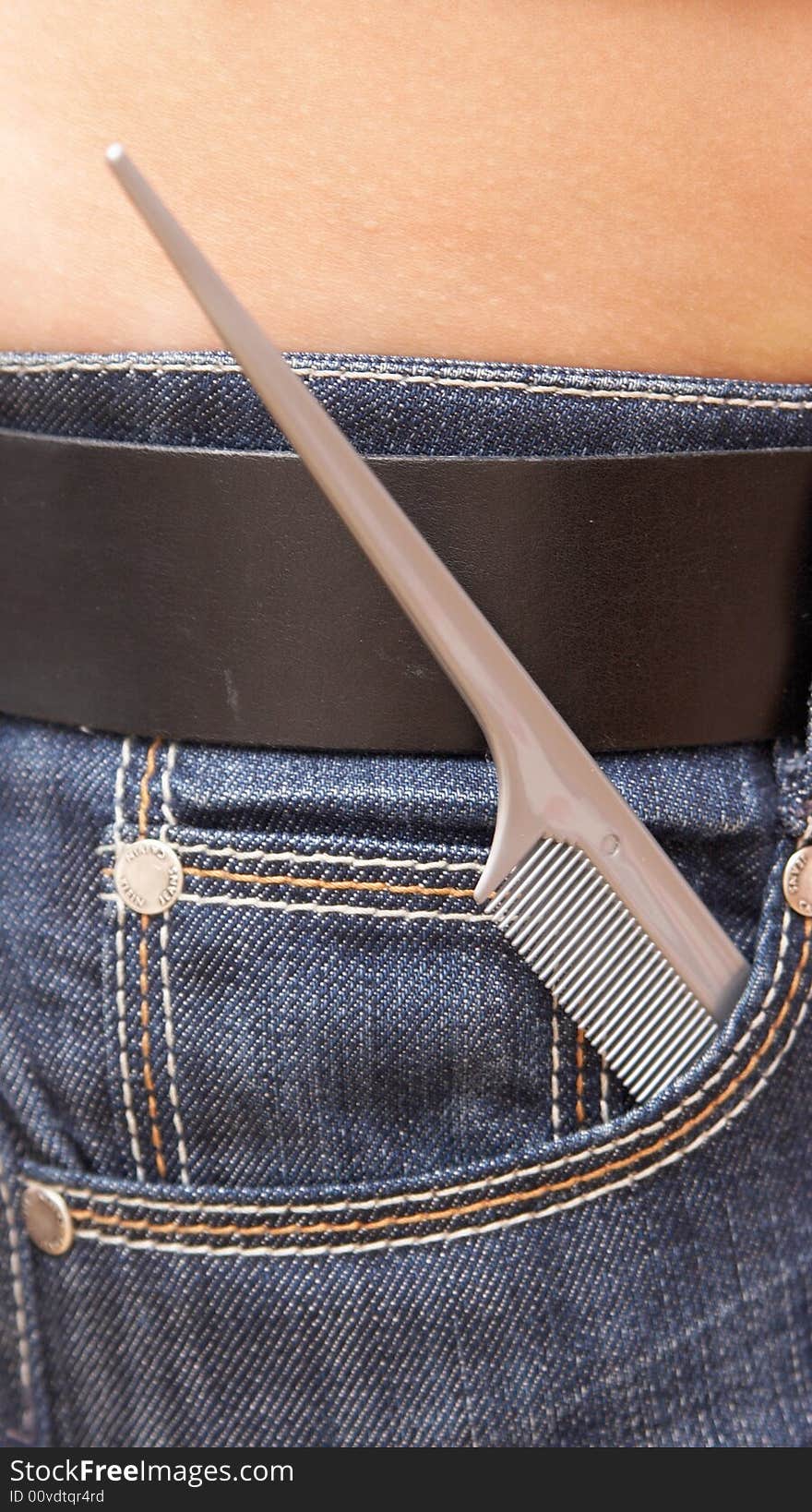 Grey hairbrush thin end in a pocket of jeans.