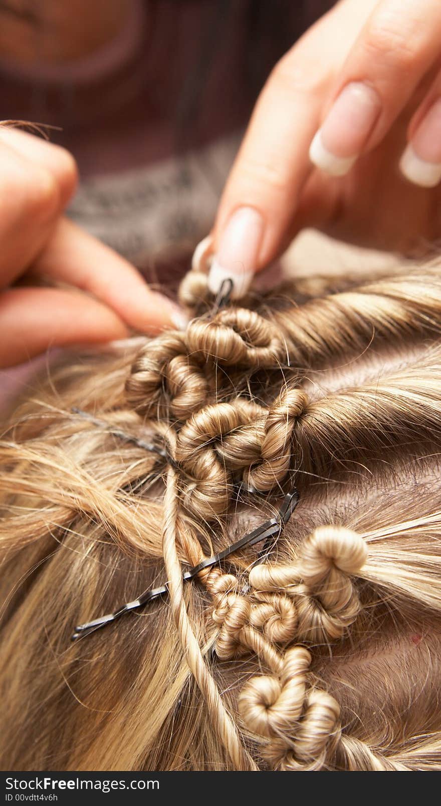 Hands of the hairdresser doing celebratory stacking of hair to the bride. Hands of the hairdresser doing celebratory stacking of hair to the bride