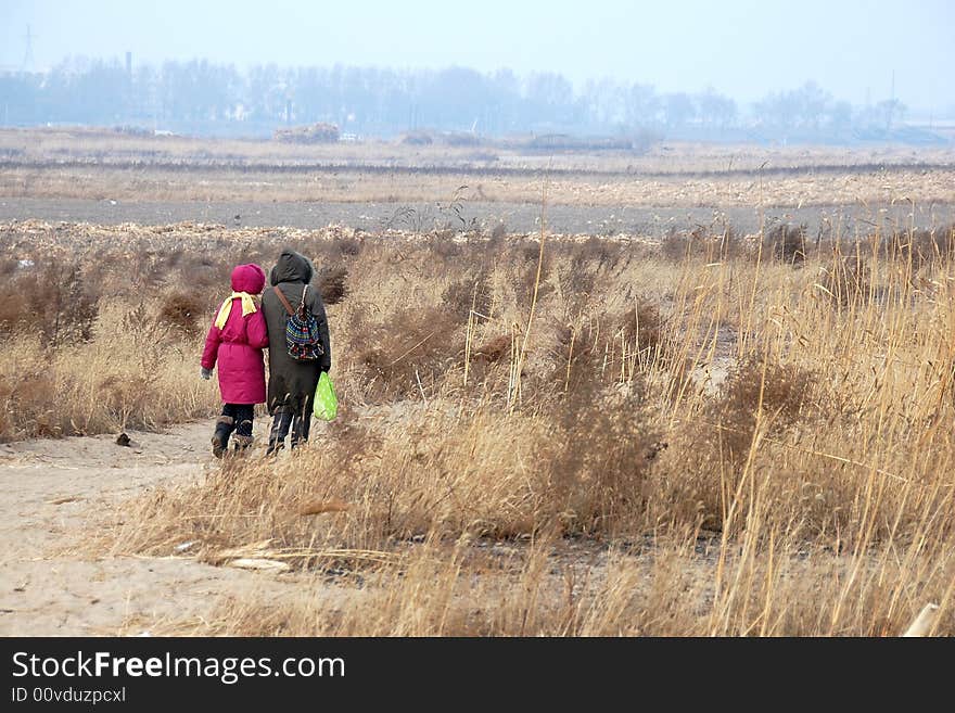 Mother and daughter are walking in wasteland in late autumn