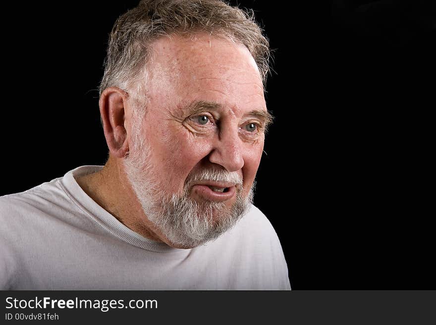 An old guy in a white t-shirt with a serious or earnest expression. An old guy in a white t-shirt with a serious or earnest expression