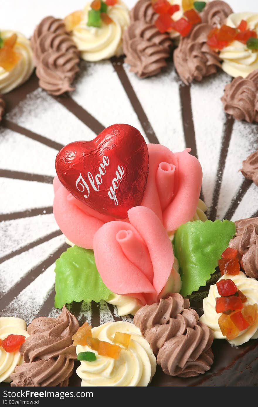 Chocolate cake with pink roses decoration and red heart.