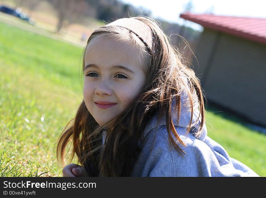 Eight year old girl laying in the grass