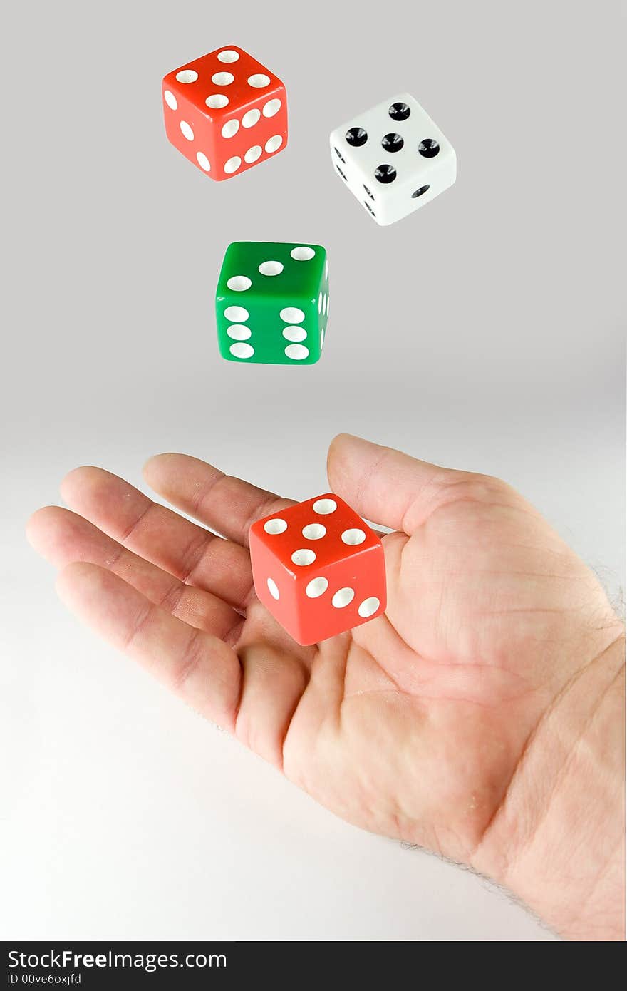 Hand and a set of dice on gray background