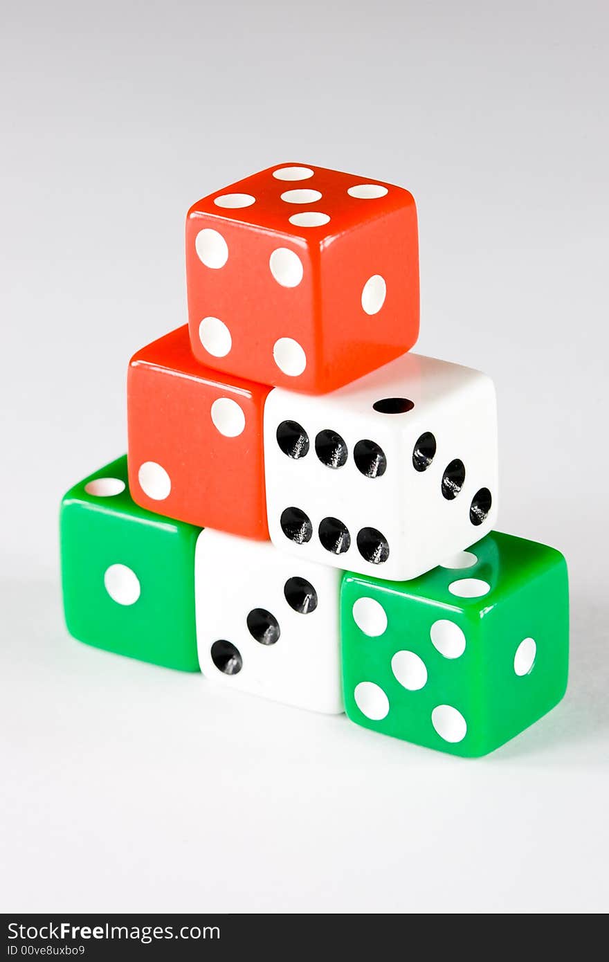 Six dice pieces in various colors, on gray background