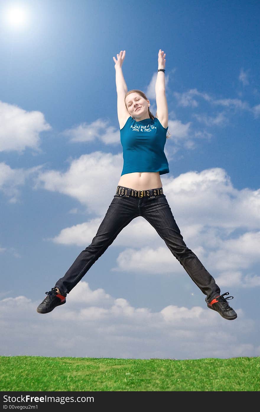 The happy jumping girl on a background of the blue sky