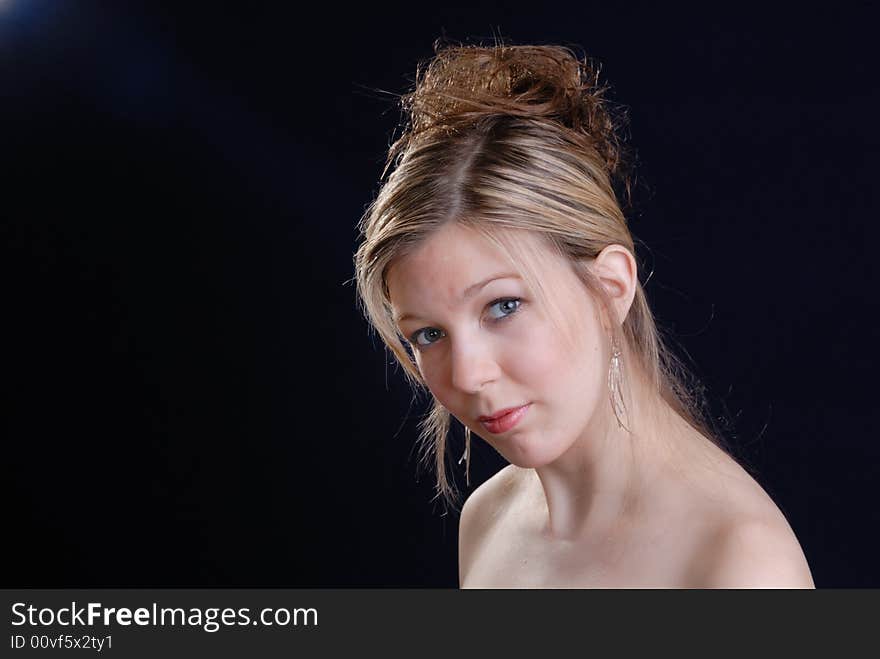 Pretty young blonde  teenage girl against dark background. Pretty young blonde  teenage girl against dark background