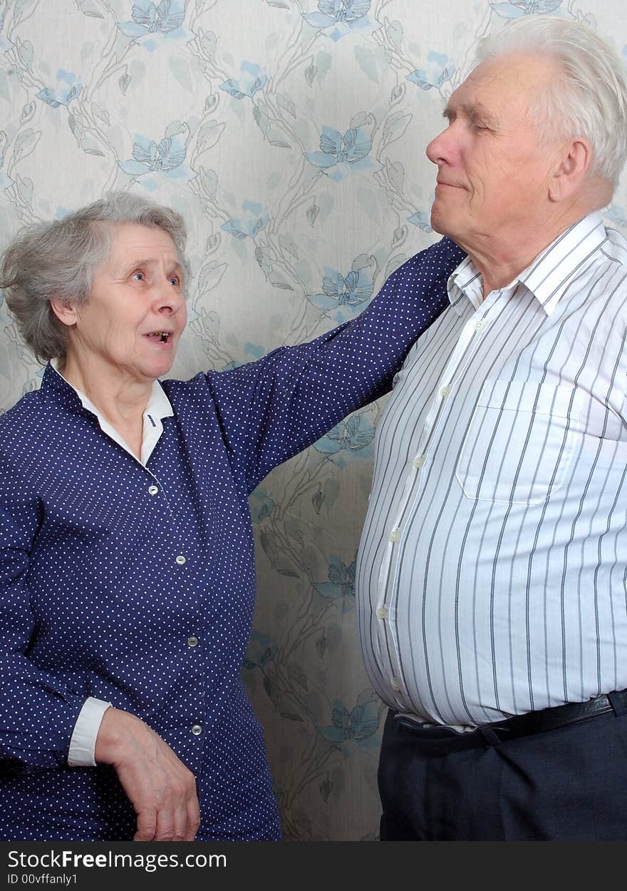 Happy old couple talking at home