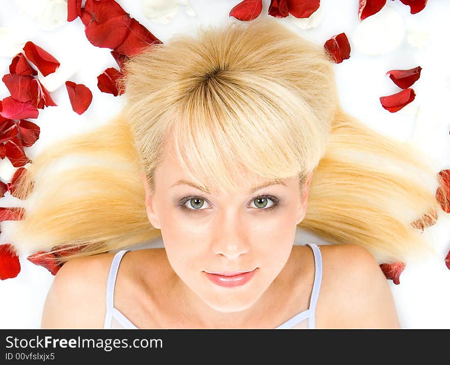 Beautiful young woman throwing rose petals against a white background. Beautiful young woman throwing rose petals against a white background