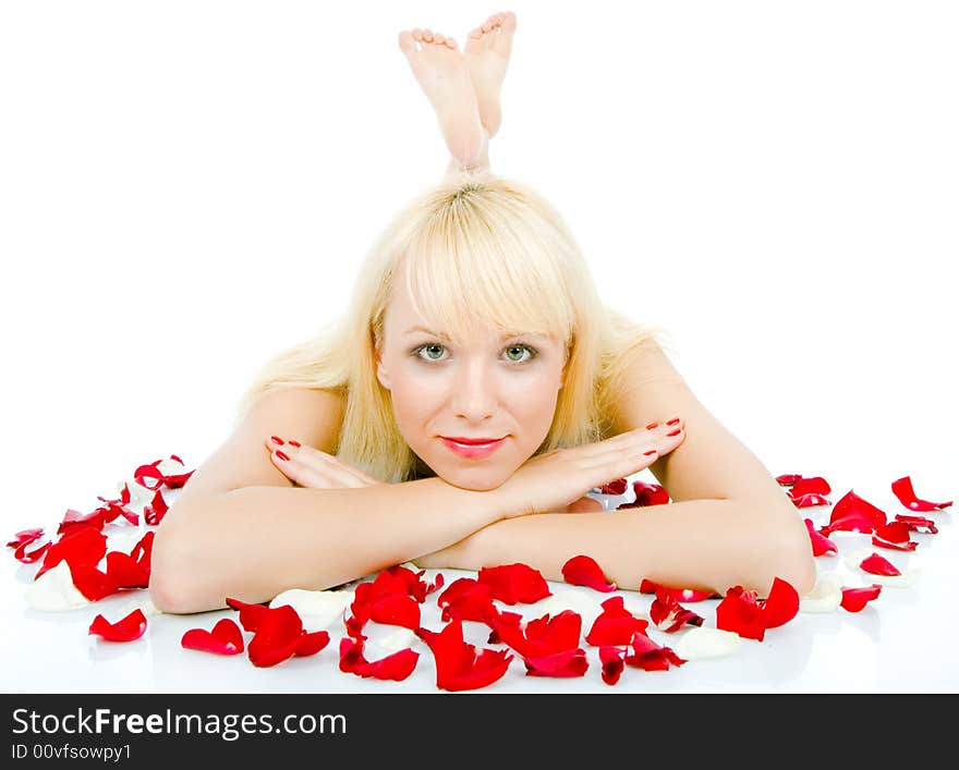 Beautiful young woman throwing rose petals against a white background