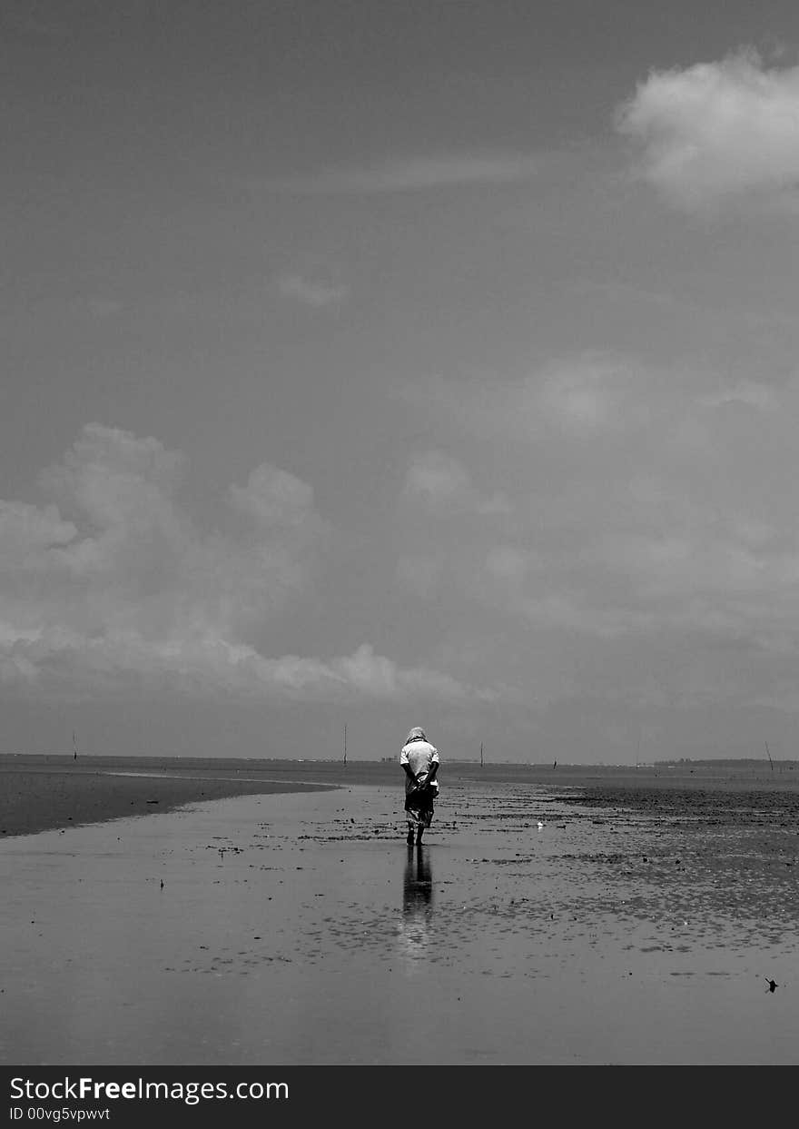 A old man walking along the Morib Beach, west coast Malysia. A old man walking along the Morib Beach, west coast Malysia.