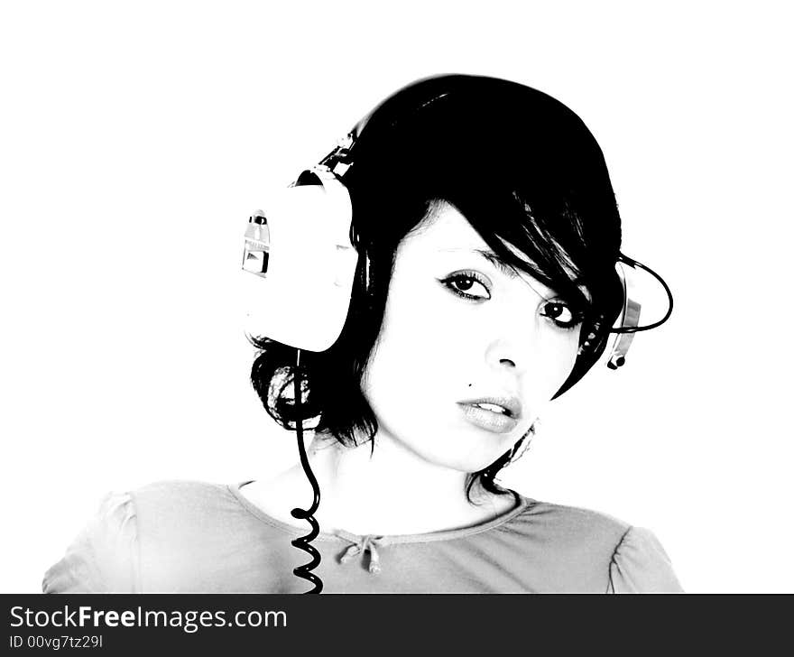 A beautiful young woman gazes with headphones on. A beautiful young woman gazes with headphones on