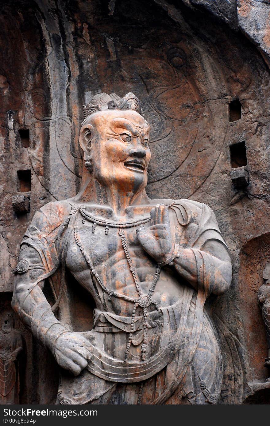 A stone statue of the Vajra, warrior of the Buddhism,chiseled out of the mountain side,Longmen Grottos,Luoyang,Henan,China.