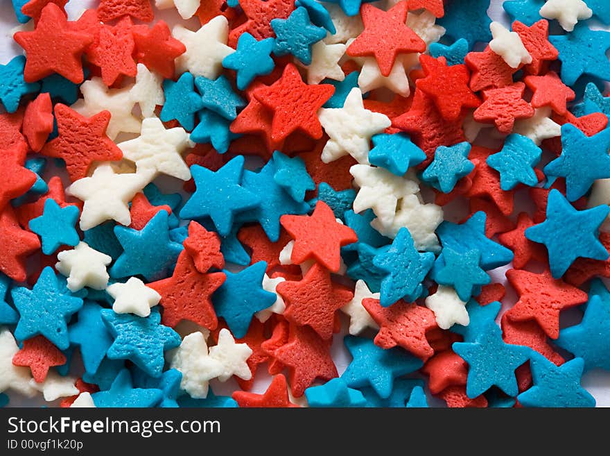 Confectionery ornament in the form of blue, red and white stars close up. Confectionery ornament in the form of blue, red and white stars close up