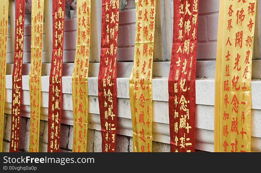 Chinese Buddhist prayer ribbons hanging at a monastery wall on Lantau