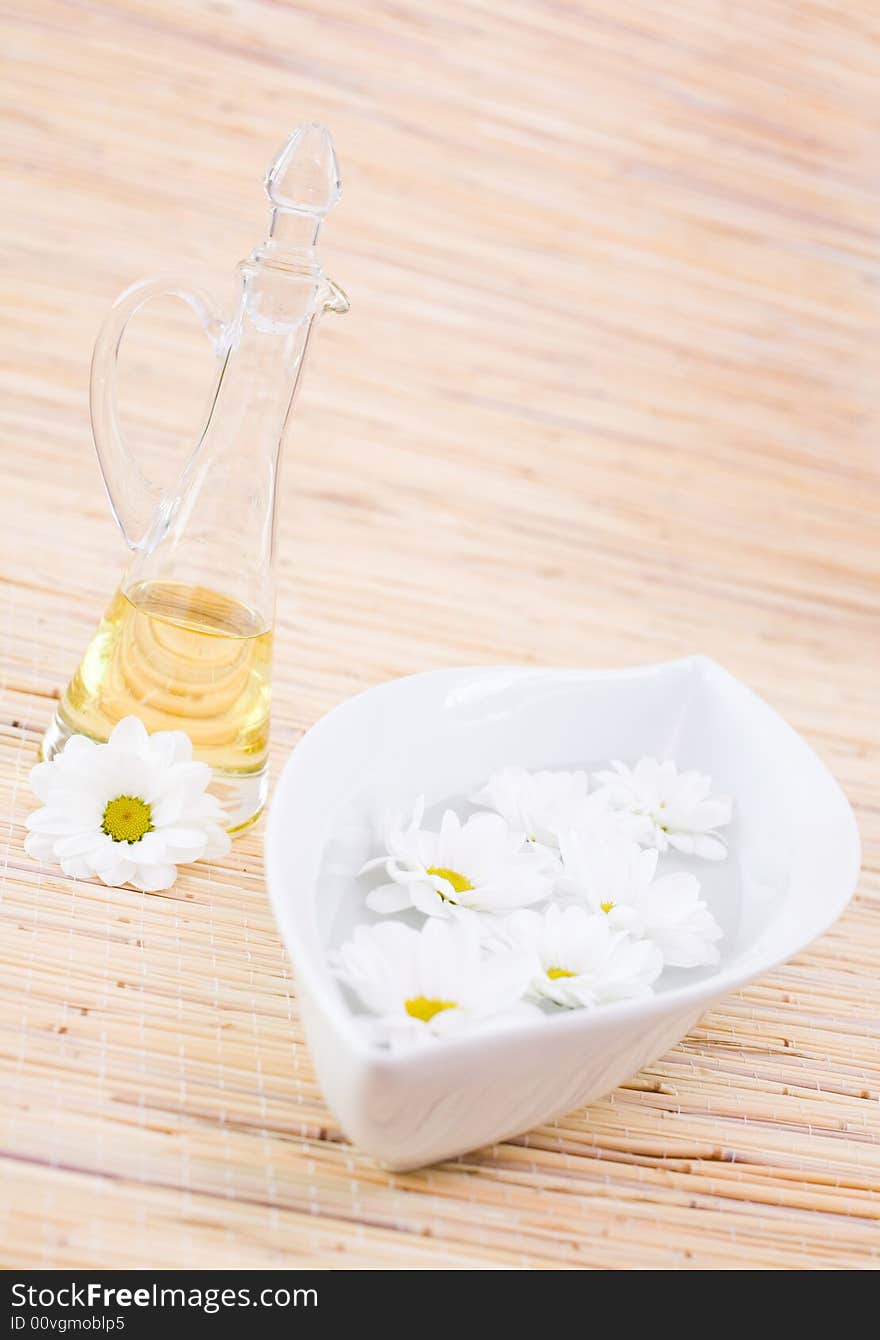 Bottle of essential oil and daisies