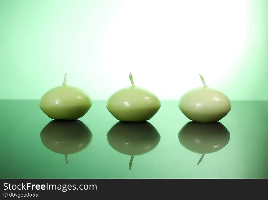 Three candles on the green background / copyspace. Three candles on the green background / copyspace