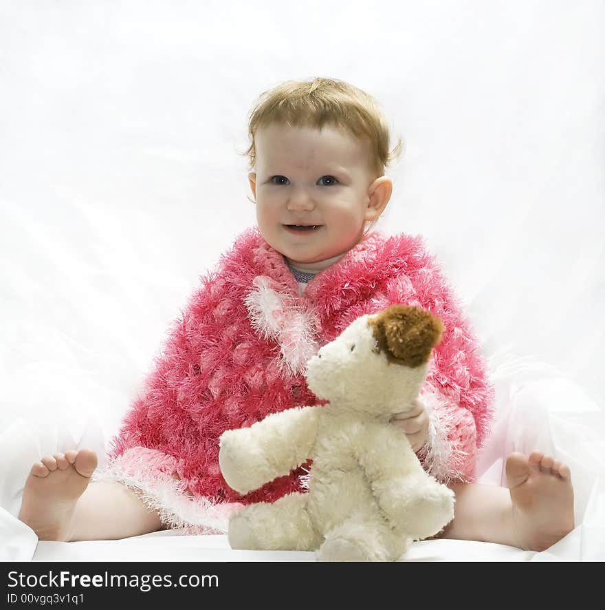 Little girl in a poncho with a toy. Little girl in a poncho with a toy