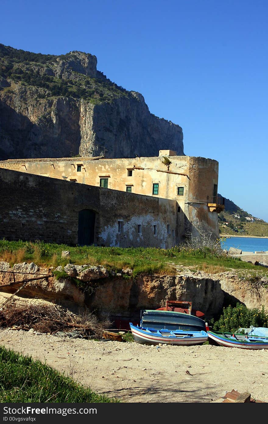 Ancient Tuna fishing construction Tonnara Bordonaro XVI century in Palermo. View on Mount Pellegrino blue sky and sea. Island of Sicily, Italy. Ancient Tuna fishing construction Tonnara Bordonaro XVI century in Palermo. View on Mount Pellegrino blue sky and sea. Island of Sicily, Italy