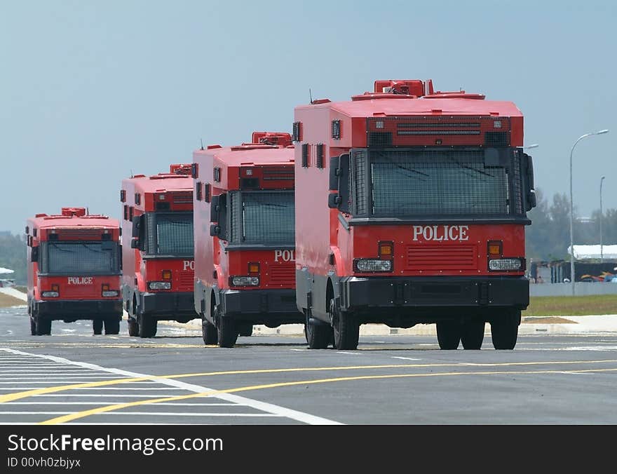 Four armoured, red police trucks, special forces for riot control etc. Shallow depth of field with the two first cars in focus. Four armoured, red police trucks, special forces for riot control etc. Shallow depth of field with the two first cars in focus.