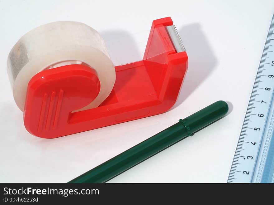 Roll of tape, pen and ruler on white background