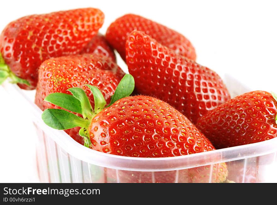 Close up of a container full of fresh strawberry over white