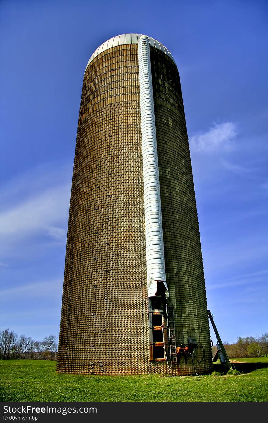 Close up of a grain silo sitting in the middle of a big field on a livestock plantation. Close up of a grain silo sitting in the middle of a big field on a livestock plantation.