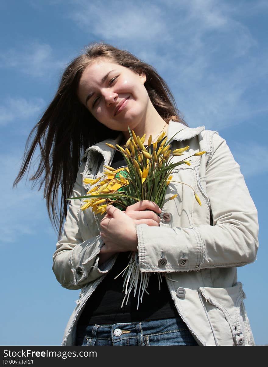 Beautiful young girl with flowers and blue sky. Beautiful young girl with flowers and blue sky