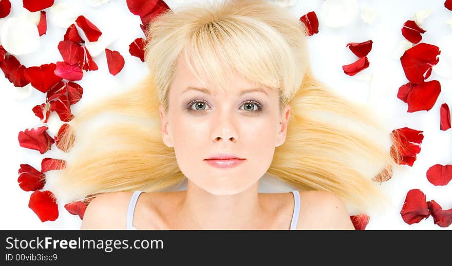 Beautiful young woman throwing rose petals against a white background. Beautiful young woman throwing rose petals against a white background