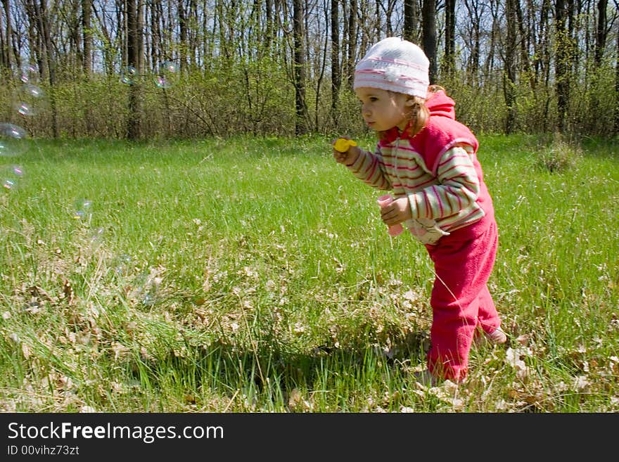 Nice child blowing soap bubbles