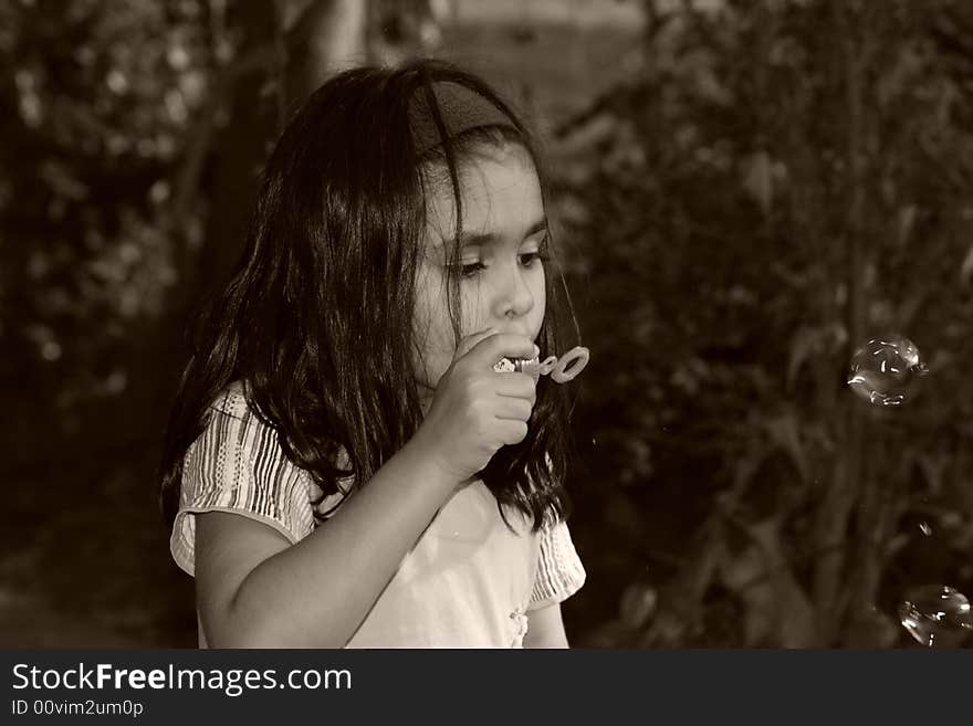 A girl releasing the bubble from her stick.