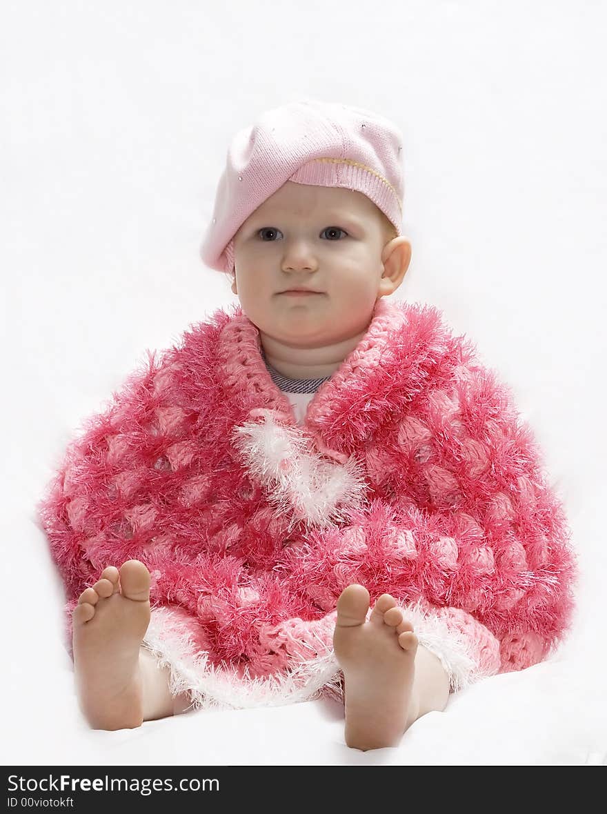 Baby in a pink poncho and beret