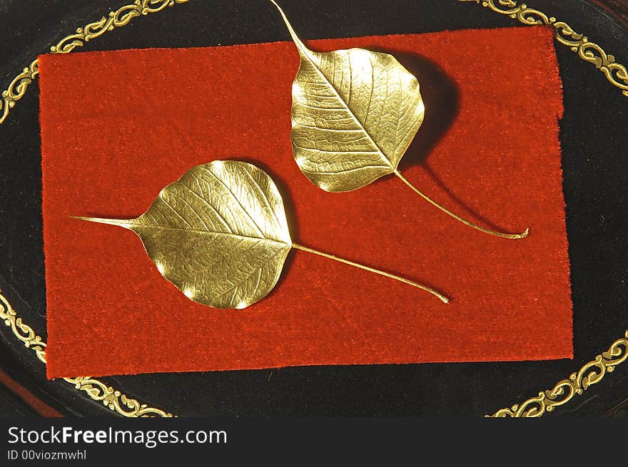 Myanmar, Mandalay: Handicraft, two golden leaves on a red background. Myanmar, Mandalay: Handicraft, two golden leaves on a red background