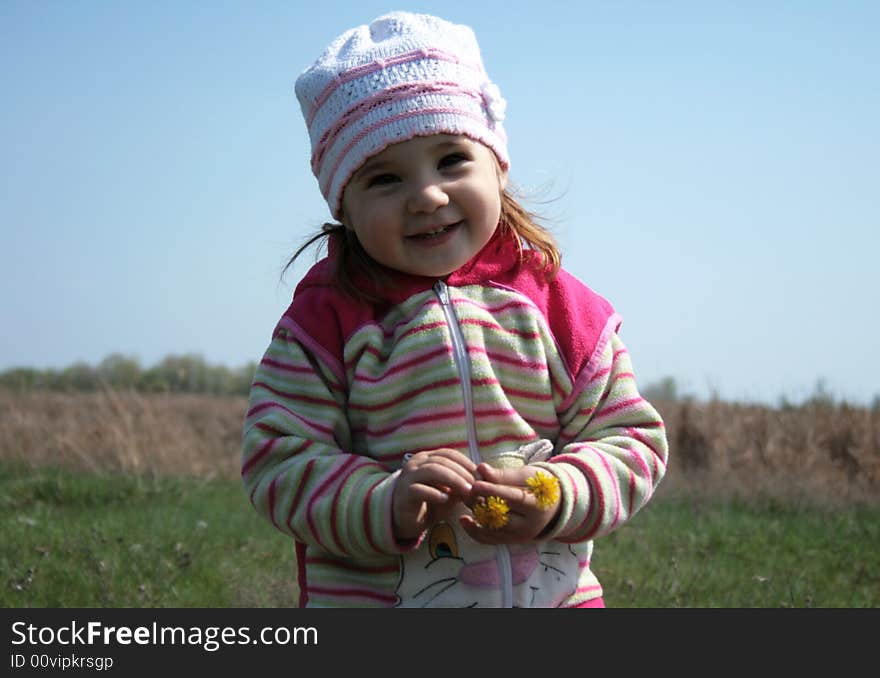 Smiling little girl playing on the meadow