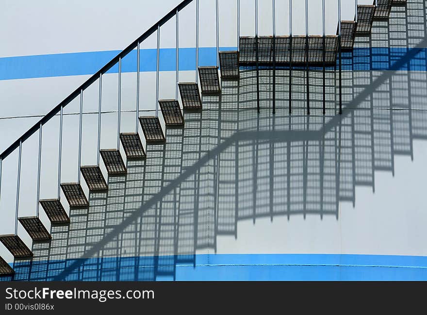 Stairs climbing a white round wall with blue lines