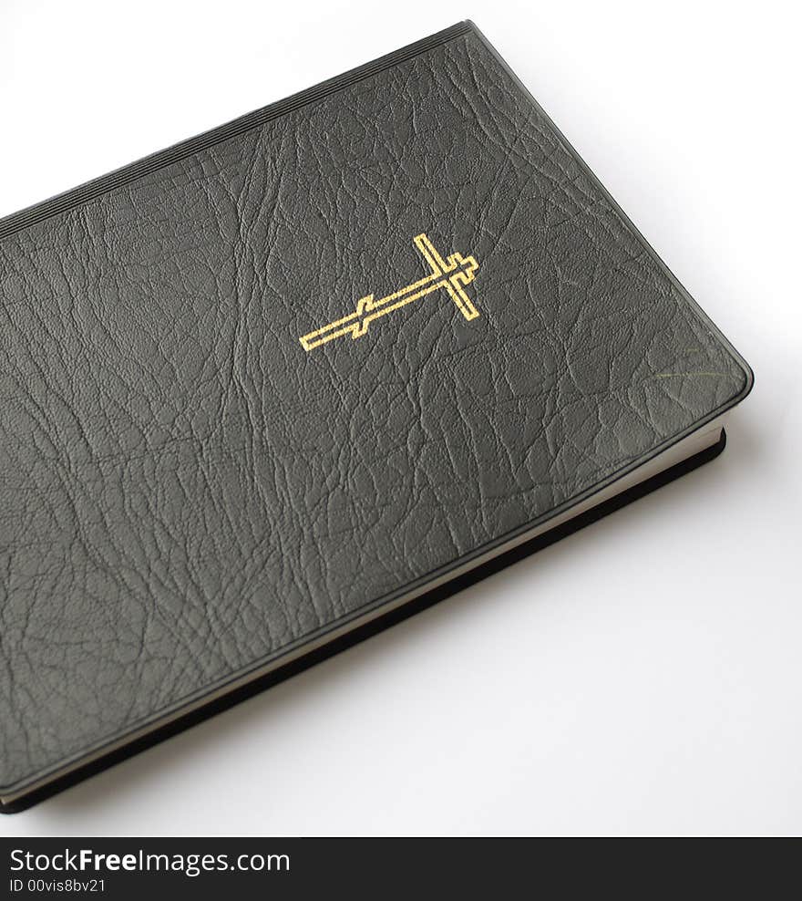 Black leather-bound bible lying on white background