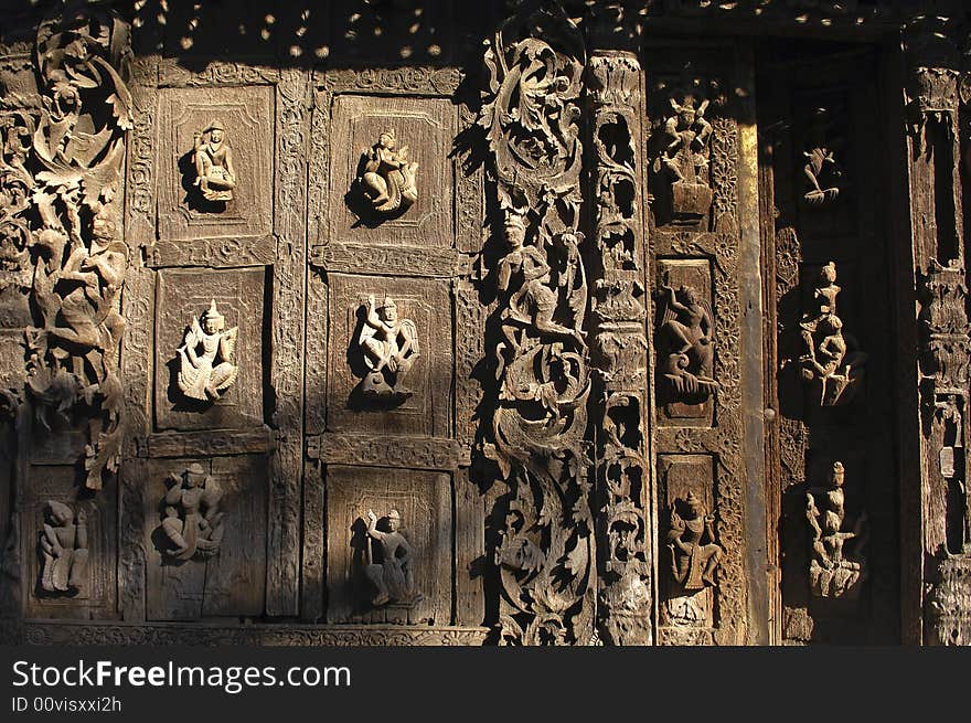 Myanmar, Mandalay: Pagoda; detail of the ancient architecture of this wood monastery; carved religious figures