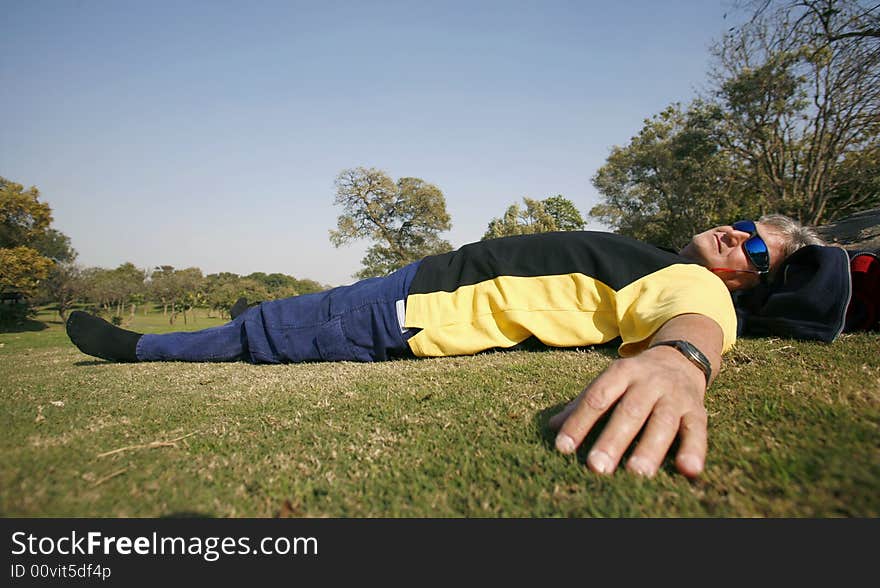 Man in park relaxing in grass