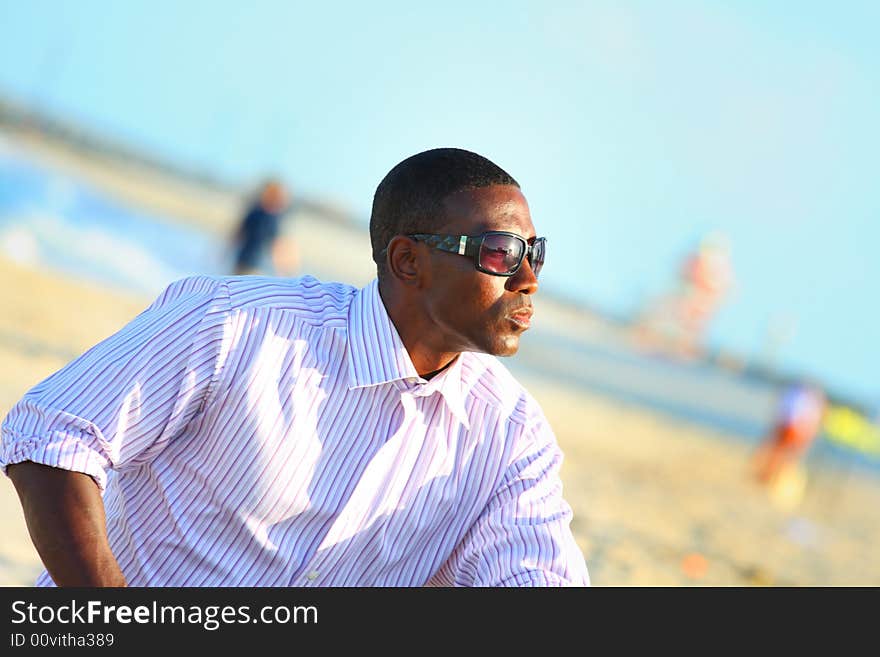 Young black businessman on the beach.