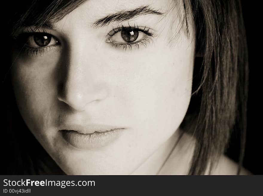 Young woman close portrait in dark sepia.