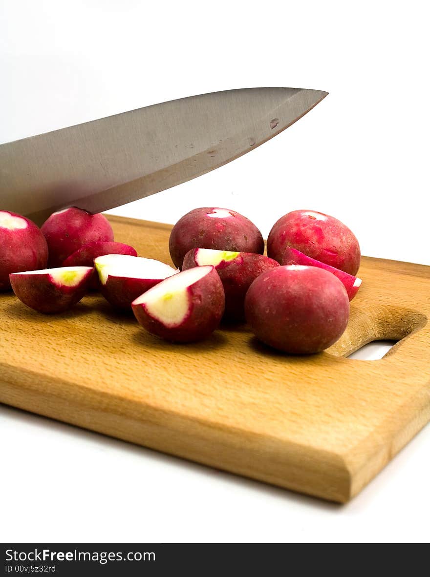 Radish and knife on wooden plate isolated