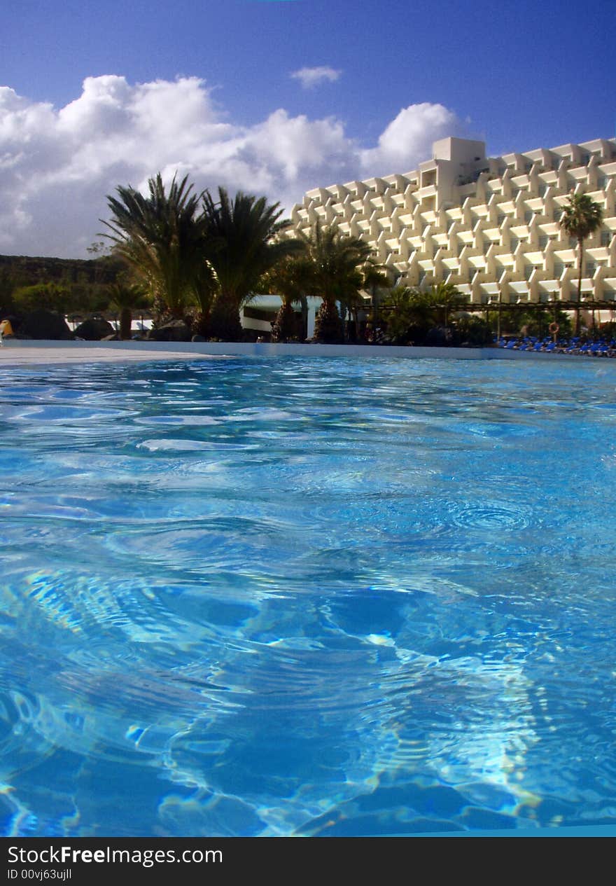 Blue pool water with a palms and hotel. Blue pool water with a palms and hotel