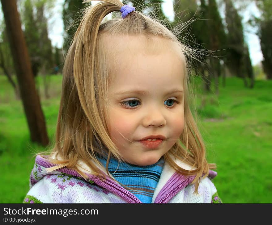 Little girl walks in the spring on a young grass