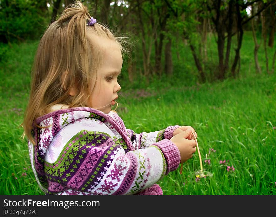 Little Girl Walks In The Spring On A Young Grass