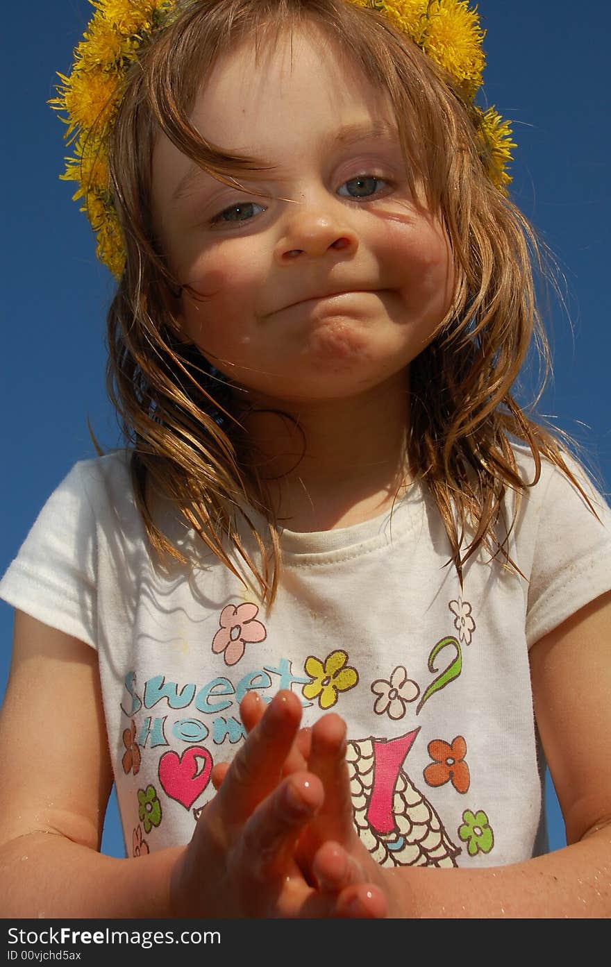 Girl wearing a dandelion diadem on a sand beach