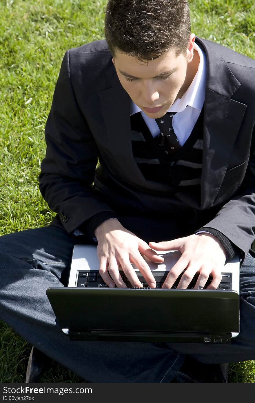 Outdoors working businessman on green grass