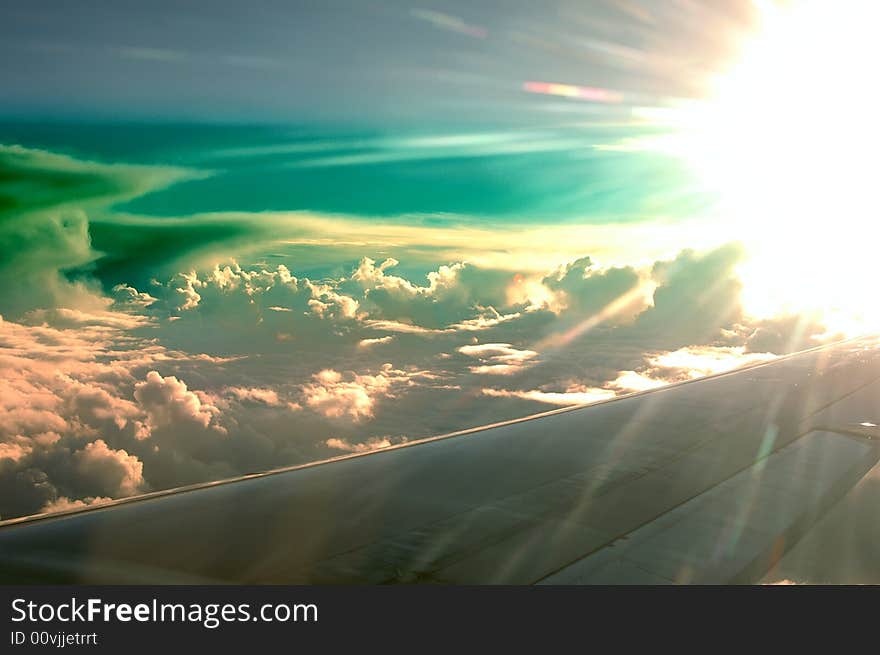 The sunny ski from a plane over the clouds with a strange turquoise color. The sunny ski from a plane over the clouds with a strange turquoise color