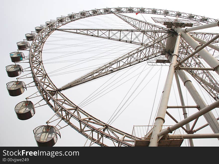 The great steel Ferris wheel in an amusement park. The great steel Ferris wheel in an amusement park.