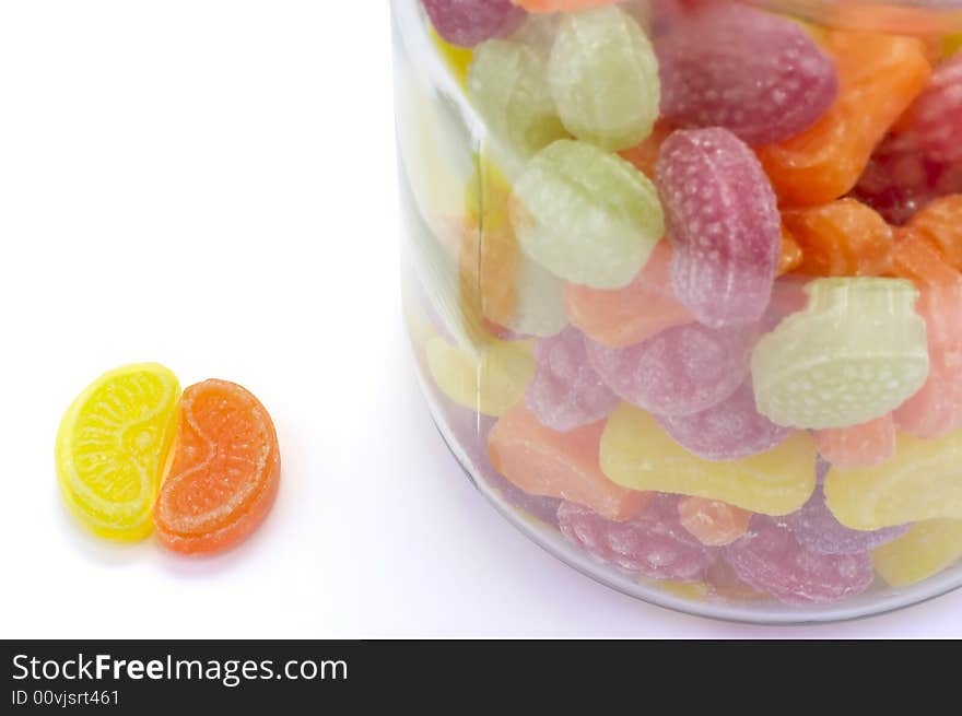 Multicolor bonbons in glass pot on the white background