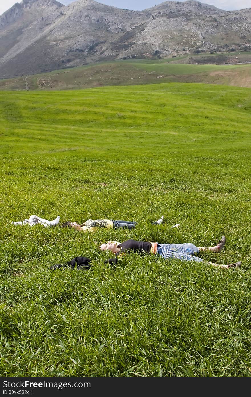 Two young friends resting on the grass. Two young friends resting on the grass