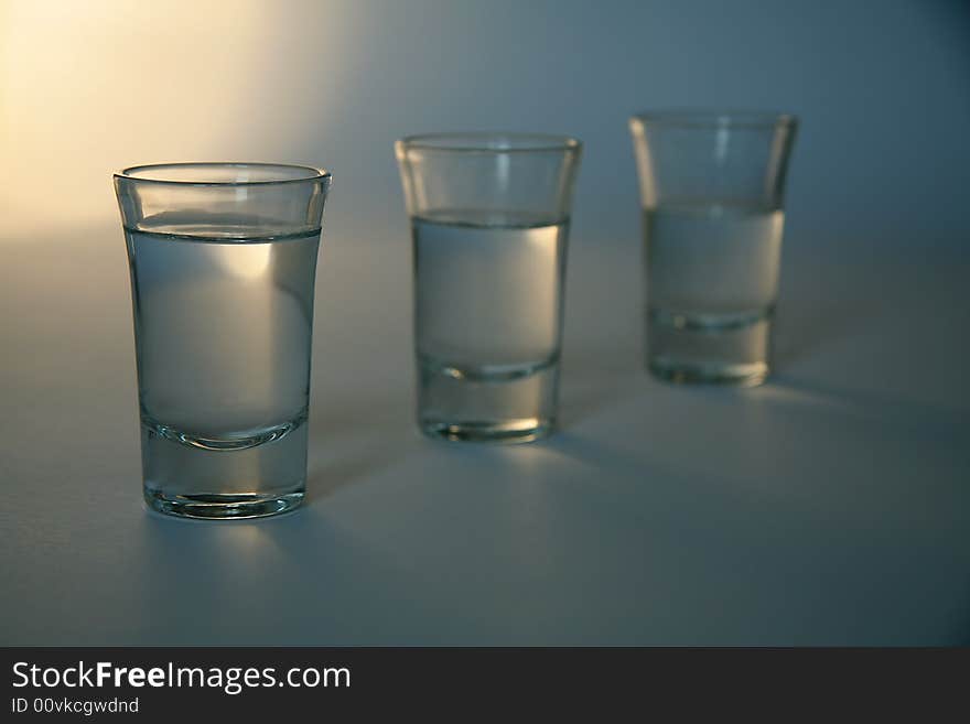 Three glasses full of alcohol, distance blur. Three glasses full of alcohol, distance blur